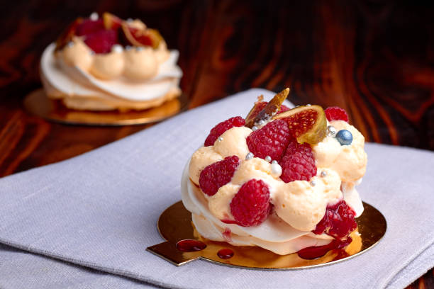 istock Two dessert Pavlova with raspberries on old brown wooden table. Meringues on a rustic background 2196808968