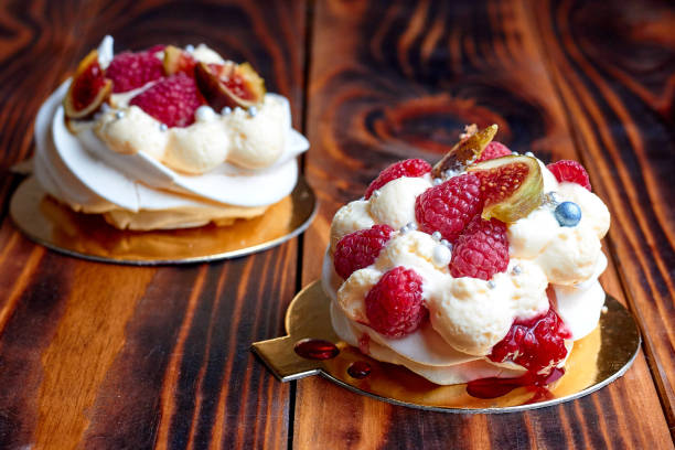 istock Two dessert Pavlova with raspberries on old brown wooden table. Meringues on a rustic background 2196808977
