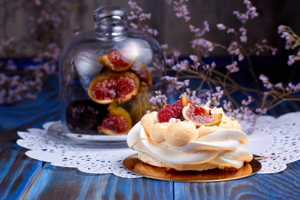 Dessert Pavlova with raspberries, on old blue wooden table. Dessert Pavlova and figs on a rustic background.