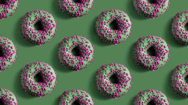Green donuts with bright pink granules, evenly arranged on a green background. A striking contrast composition.