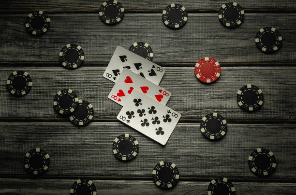 istock A thrilling poker game unfolds on a rustic wooden table, featuring a three of a kind or set combination and various poker chips scattered around, creating a tense atmosphere for the players 2196812434