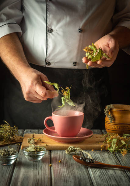 istock Herbalist brews tea from medicinal dry herbs. Hand holds dry medicinal linden, which can be added to the cup. Concept of traditional medicine or treatment of flu virus 2196813064