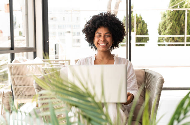 istock Young woman working remotely from a bright and tropical patio 2196815724