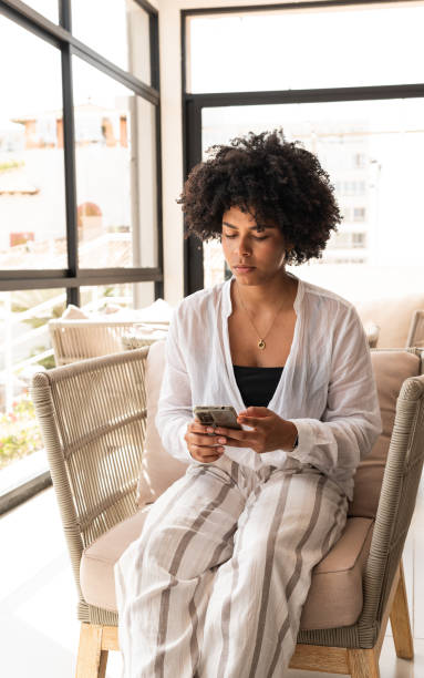 istock Young woman using mobile phone in a modern cafe 2196815885