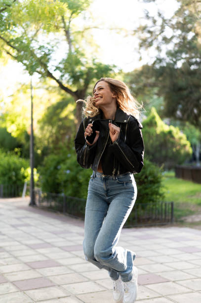 Young woman jumping with joy in a park