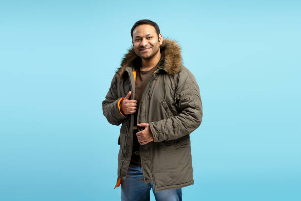 istock Smiling man wearing winter jacket on blue background 2196818449