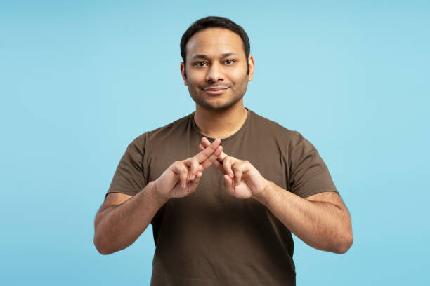 istock Confident man showing crossed fingers, making x sign to refuse something 2196818473