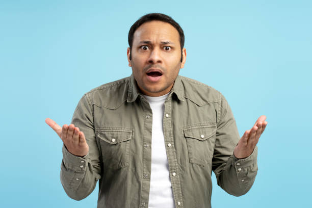 istock Shocked man showing confused gesture with open mouth and palms up 2196818540