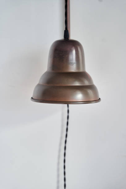 istock A lamp made of copper hangs from a wooden pole on a white wall 2196819061