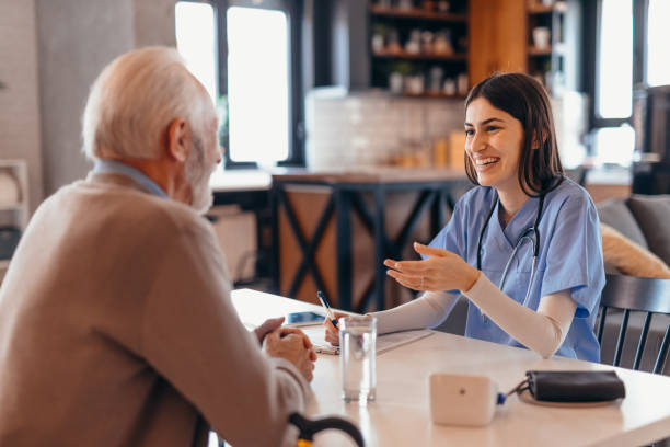istock Young nurse assisting a senior man at home 2196821205