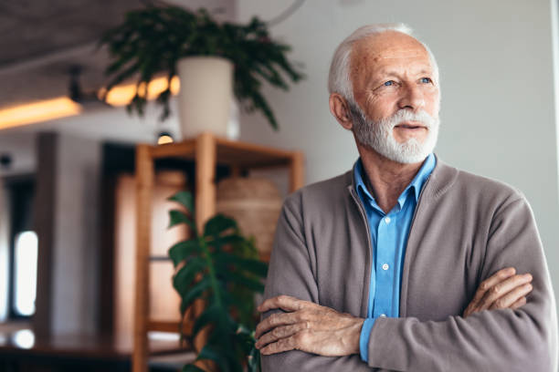 Confident senior man with crossed arms looking away, planning future