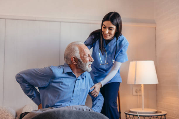 istock Nurse helping senior man getting up from bed 2196821446