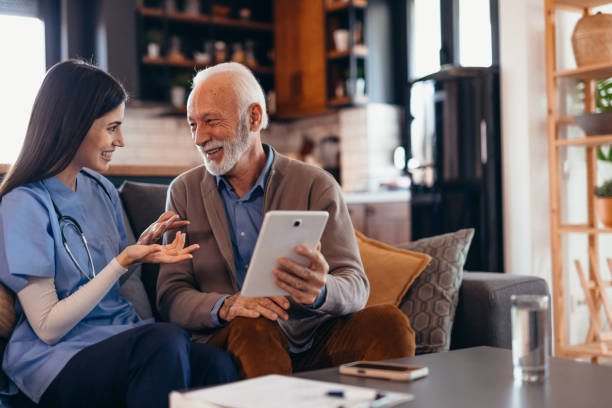 istock Nurse assisting senior man using digital tablet at home 2196821457