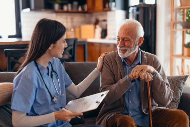 istock Young nurse supporting a senior man holding a walking stick at home 2196821529
