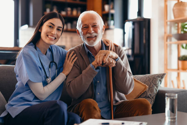 istock Nurse supporting happy senior man holding walking cane at home 2196821567