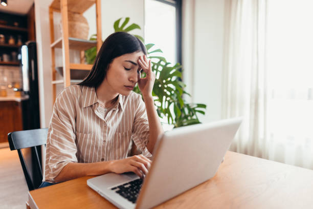 istock Stressed young woman working from home having a headache 2196821574
