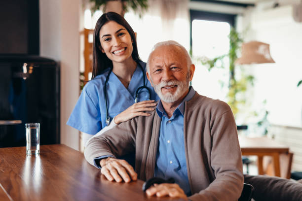 istock Nurse smiling and assisting elderly man in nursing home 2196821593
