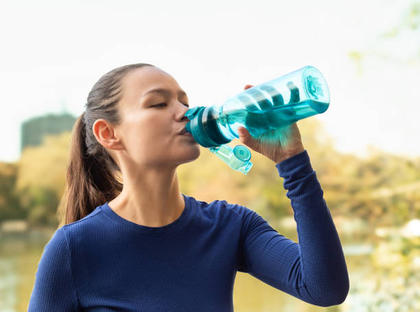 istock Young female drinking water from water bottle. 2196828898