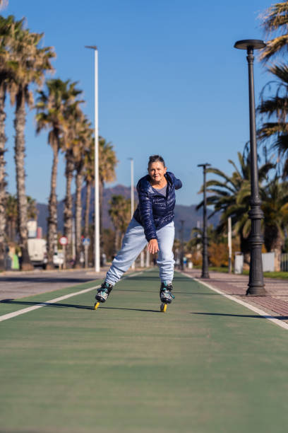 Senior woman roller skating in a city park, maintaining a healthy and active lifestyle
