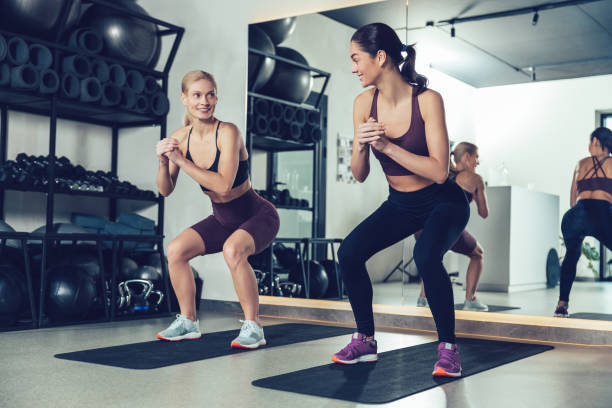 istock Two young women doing squats in the gym during workout 2196830914