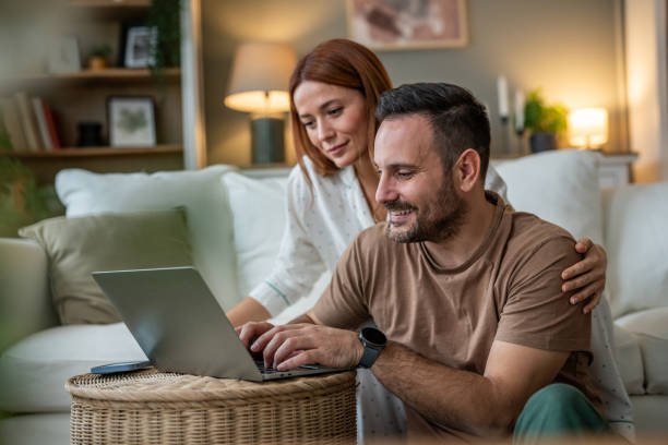istock Couple using a laptop together on the sofa 2196835690