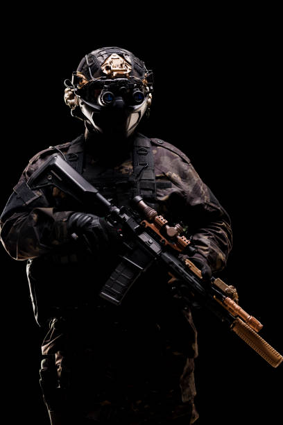 istock Tactical soldier in full combat gear holding advanced rifle in low light 2196836144