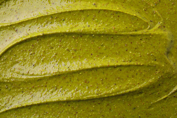 Tasty pistachio cream as background, top view
