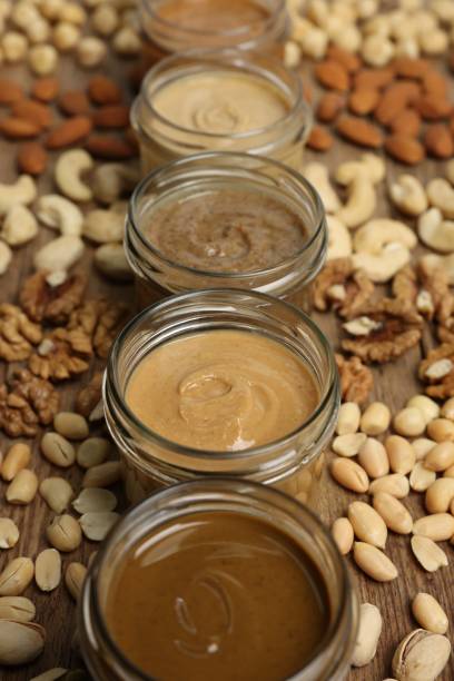 istock Nut butters in bowls and ingredients on wooden table, closeup 2196837663