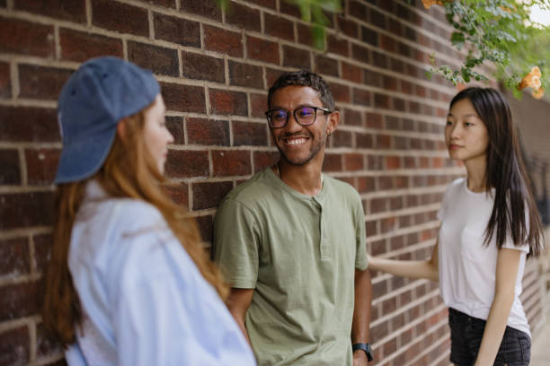 istock Friends Socializing Outdoors Near a Brick Wall in a Relaxed Atmosphere 2196837821