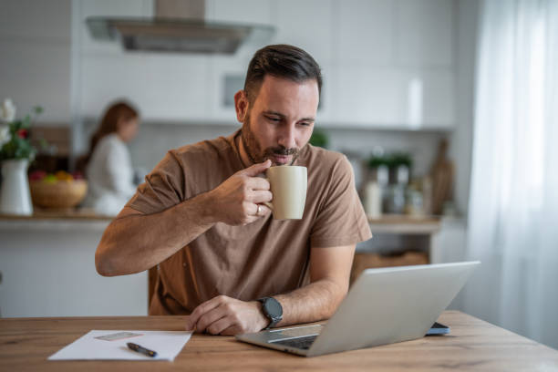 istock Happy man sipping coffee and working on his laptop 2196838305