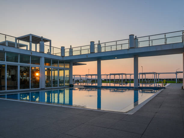 Serene evening at a modern waterfront poolside retreat with vibrant sunset hues