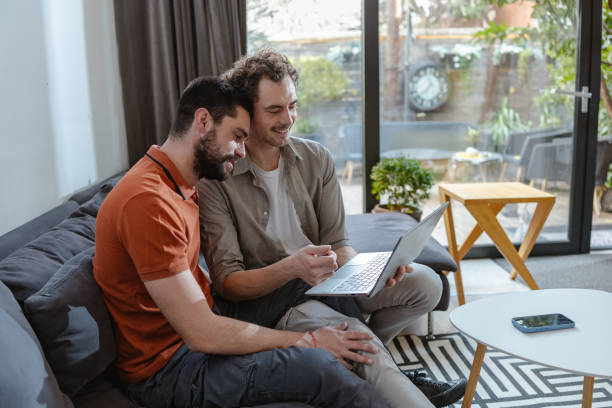 istock Happy LGBT couple sharing moments on a sofa using a laptop at home 2196839201