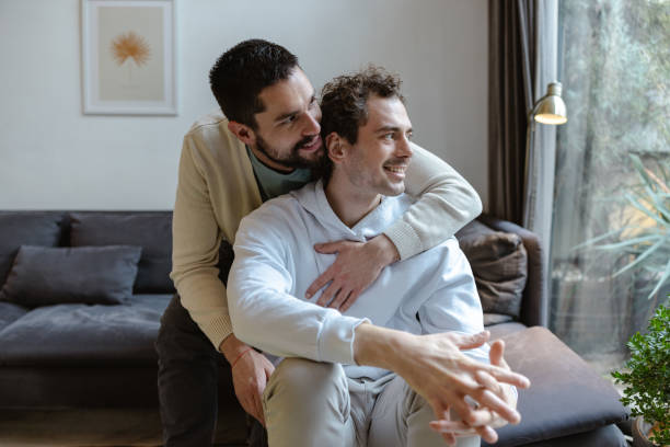 istock Happy same-sex couple embracing in a cozy home environment 2196839430