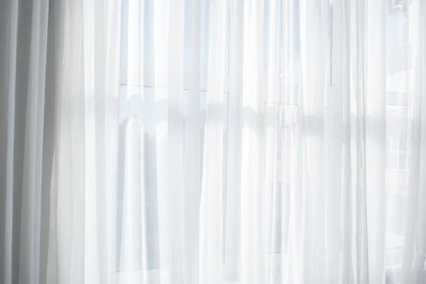 istock Soft light filters through sheer white curtains in a bright room 2196840945