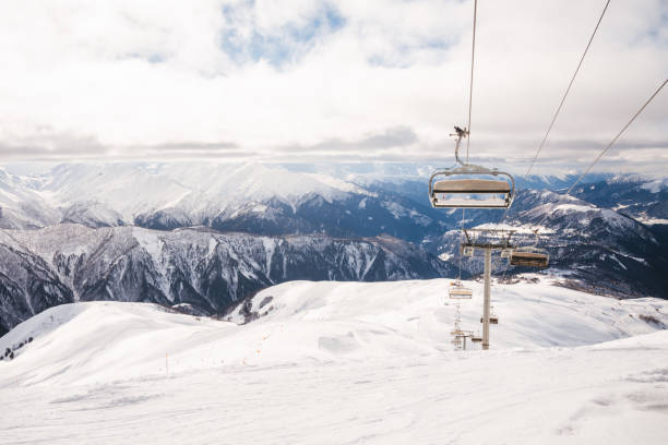Ski resort in Alps of France. Red chairs outside on sunny day in winter. Holidays and sports.