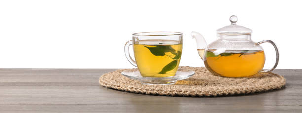 istock Refreshing green tea in cup and teapot on grey wooden table against white background 2196841691