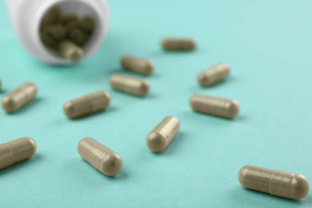 istock Bottle and vitamin capsules on turquoise background, closeup 2196843946