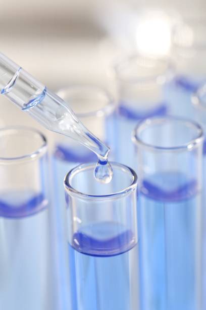 istock Laboratory analysis. Dripping light blue liquid from pipette into glass test tube on blurred background, closeup 2196844005