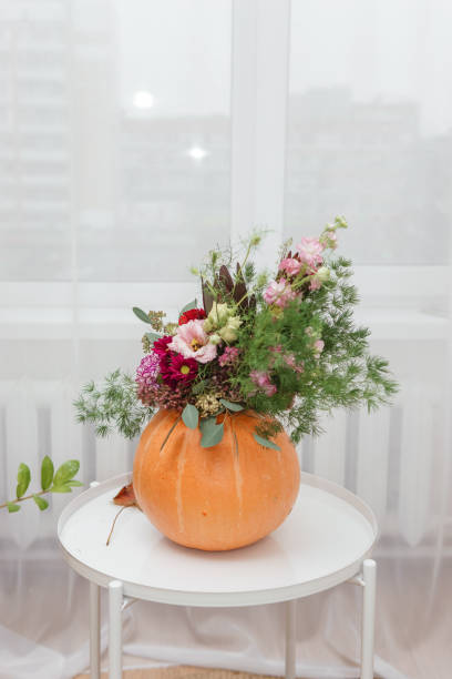 istock Flower arrangement in a pumpkin, autumn interior decor. Creating handmade autumn decor. 2196848452