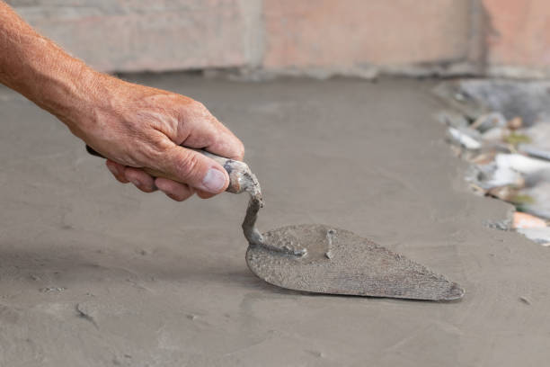istock Cementation of a garden path.A man manually spreads the cement mixture with a trowel.Spring work in the garden. 2196852273