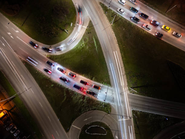 istock Top down aerial view of a night intersection with a moving traffic. Vehicles create dynamic light trails, showcasing urban speed, motion, and modern transportation infrastructure 2196852292