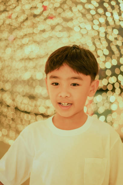 Close-up face boy enjoys walking around looking at decorative lights.