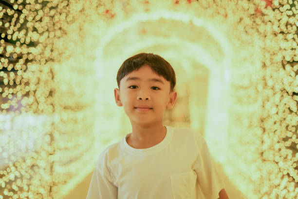 Child boy enjoys walking around looking at decorative lights.