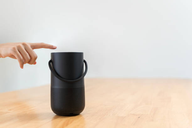 istock Close-up of hand pressing a button on a wireless Bluetooth speaker surrounded by blurred background. 2196867837