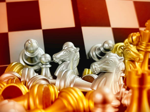 Horse head or Knight of chess put between blurred other figure on checkedboard,blurry light around