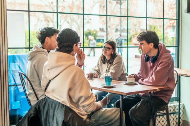 istock Diverse college students sitting around cafe table, drinking coffee and engaging in animated conversation, sharing camaraderie and connection 2196871759