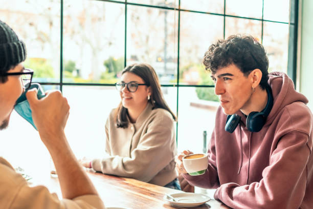 istock College students relaxing over coffee, sharing conversation in sunlit cafe, embodying camaraderie and collaborative learning atmosphere 2196871771