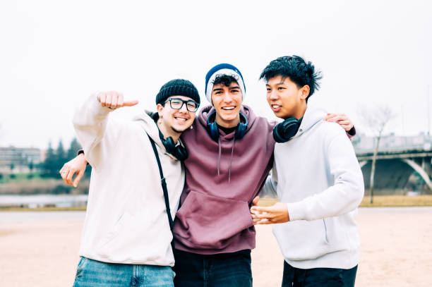 istock Multiethnic male students hugging, smiling while bonding outdoors, expressing friendship and shared joy during college life 2196871808