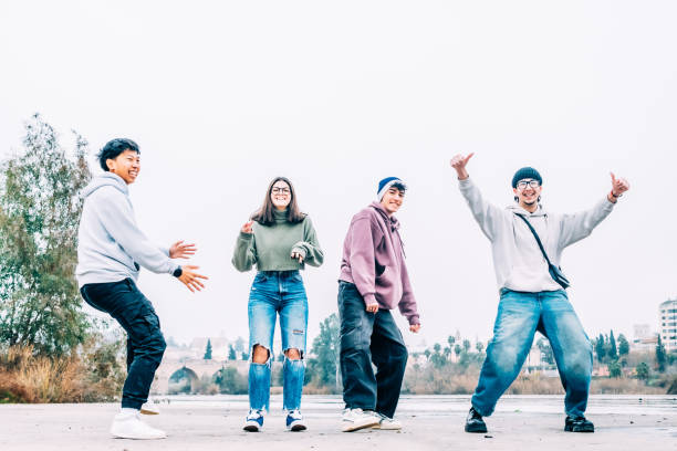 istock Multicultural college friends dancing, laughing, bonding near riverside, expressing joyful camaraderie and shared excitement during free time together 2196871843