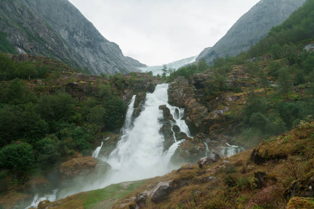 Scenic view of powerful waterfall from glacier lake in Norway
